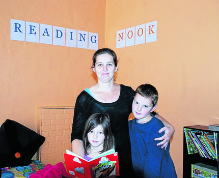 Nicole McKenzie, owner of Inspire, Write and Educate stands in front of the book nook with her children Elizabeh and Tyler.  Photo: Supplied.